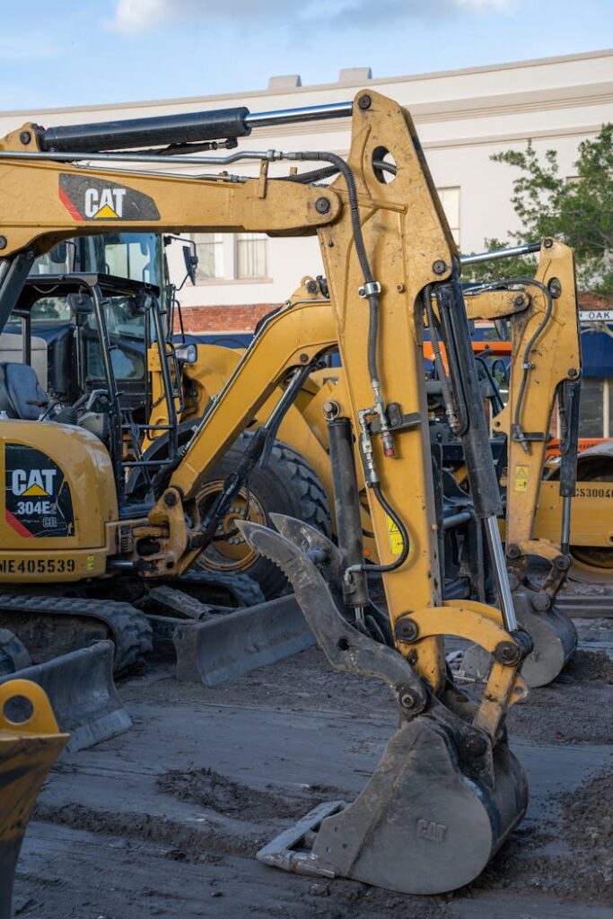 pexels photo 11973725 Yellow excavators at a construction site with machinery and equipment in the foreground.